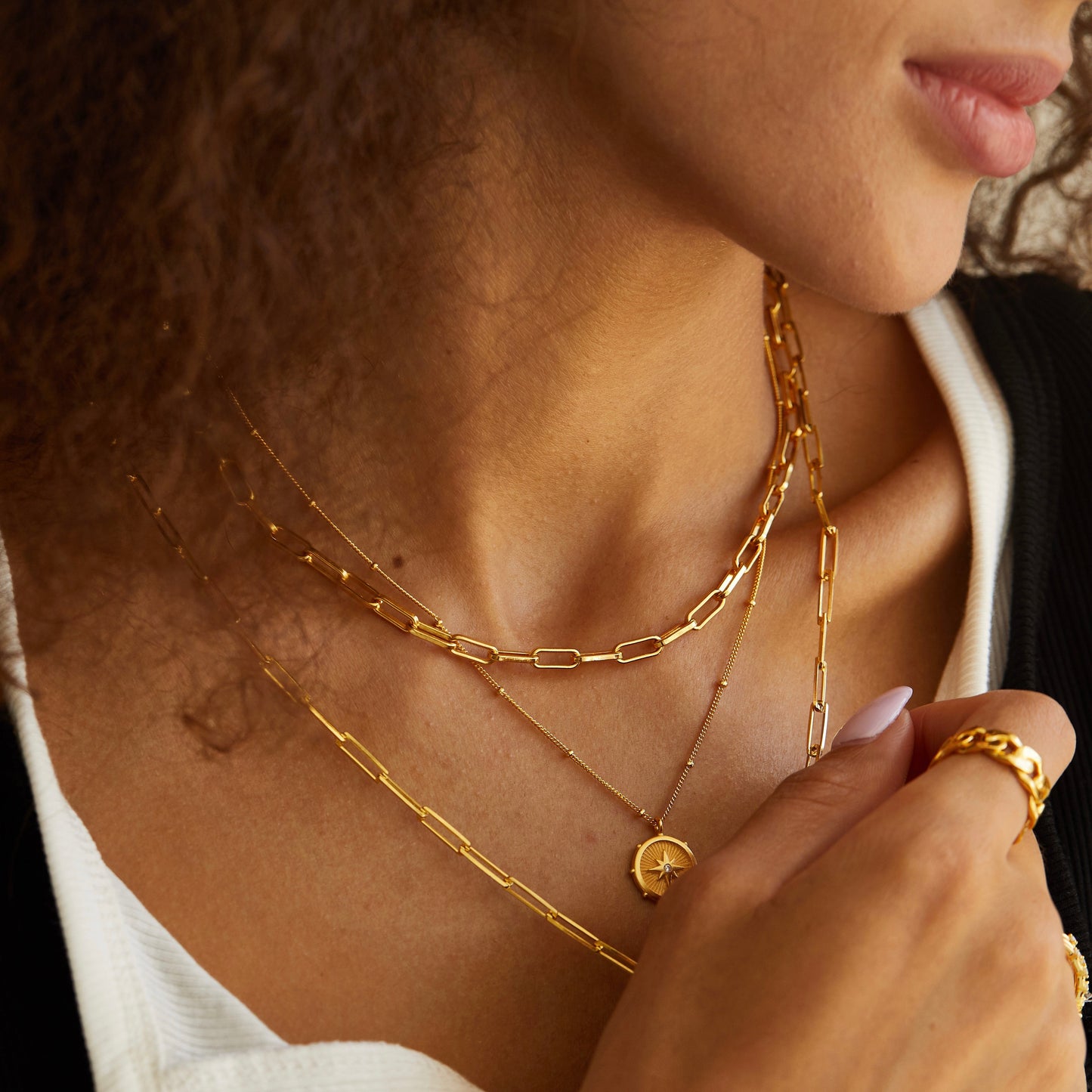 Gold paperclip necklace layered with fine gold necklaces