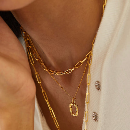 Gold paperclip necklace layered with fine gold necklaces
