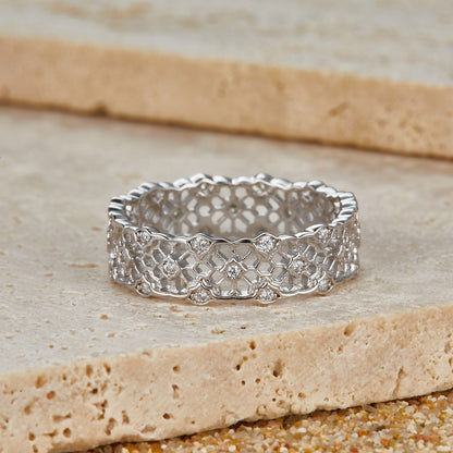 Awakened Time Iceveil Band resting on natural stone, showcasing its intricate Parisian-inspired white gold vermeil filigree pattern and sparkling cubic zirconia stones.