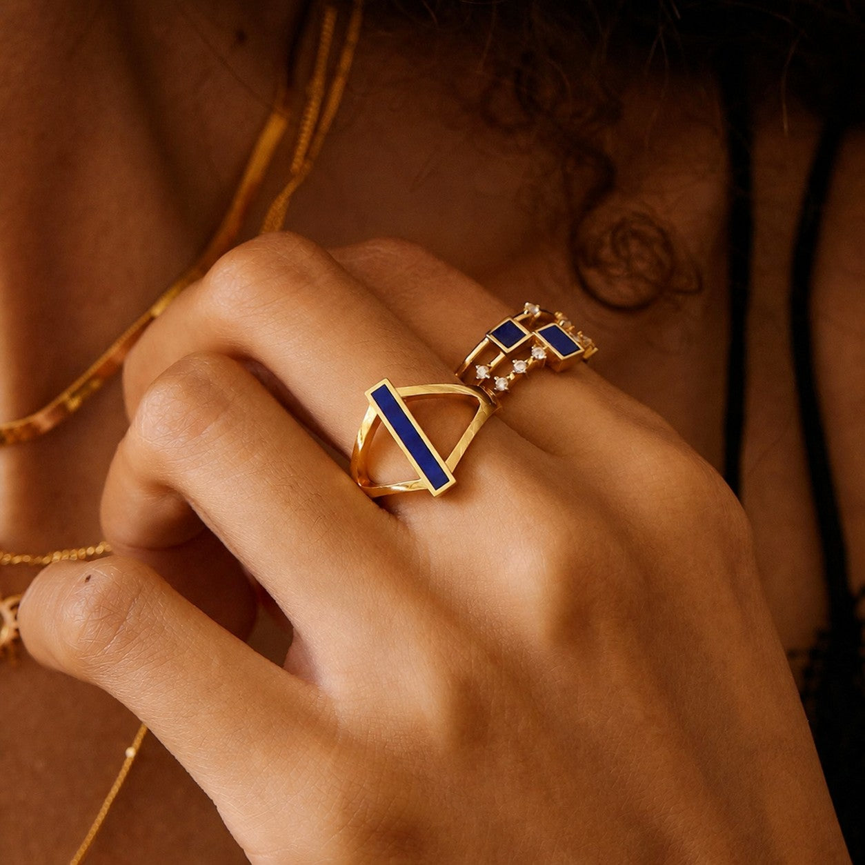 Woman wearing the Indigo Bridge Ring by Awakened Time, featuring a natural lapis lazuli gemstone and elegant geometric gold design.