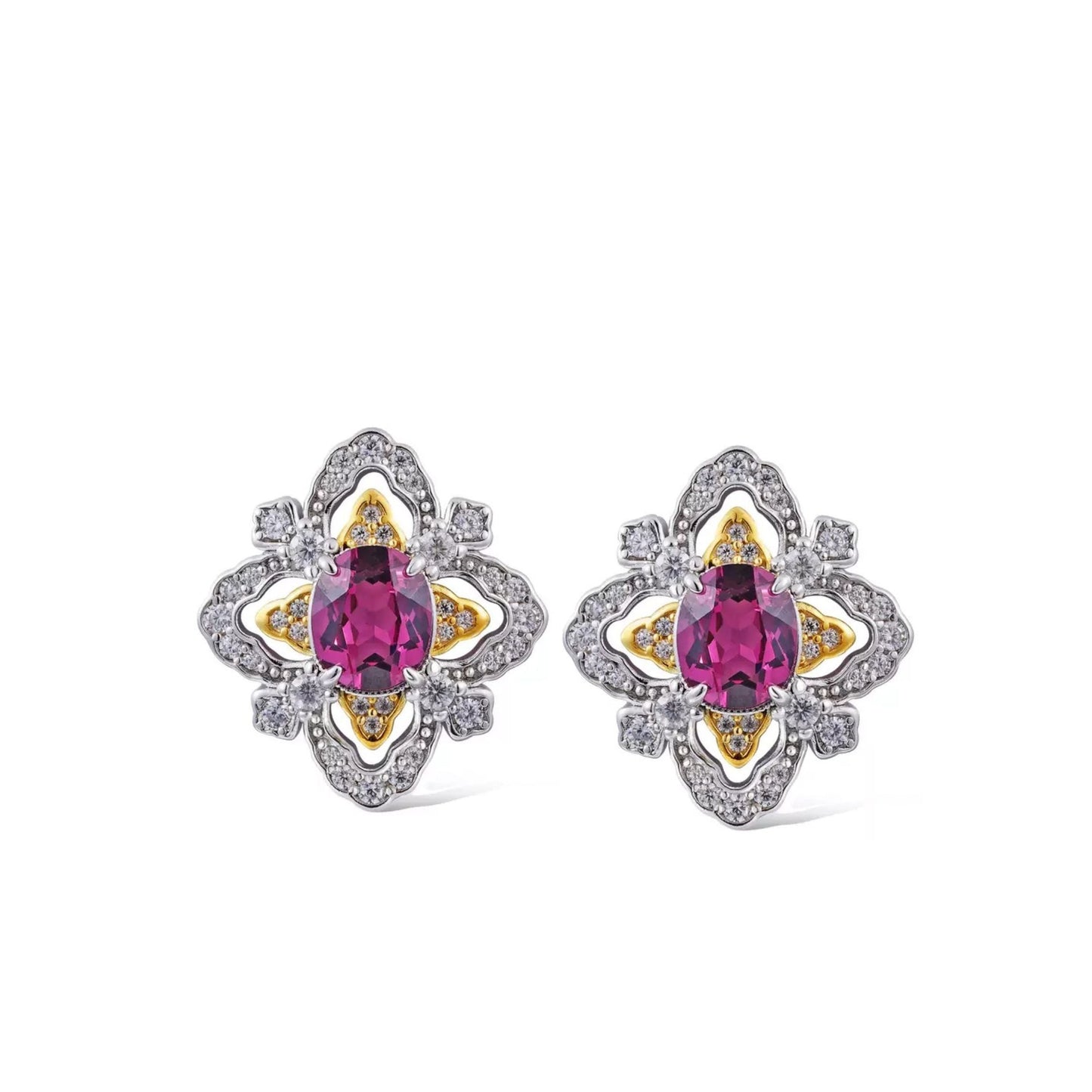 Pair of La Rosa di Firenze garnet earrings resting on a white display plate over a rich brown surface.