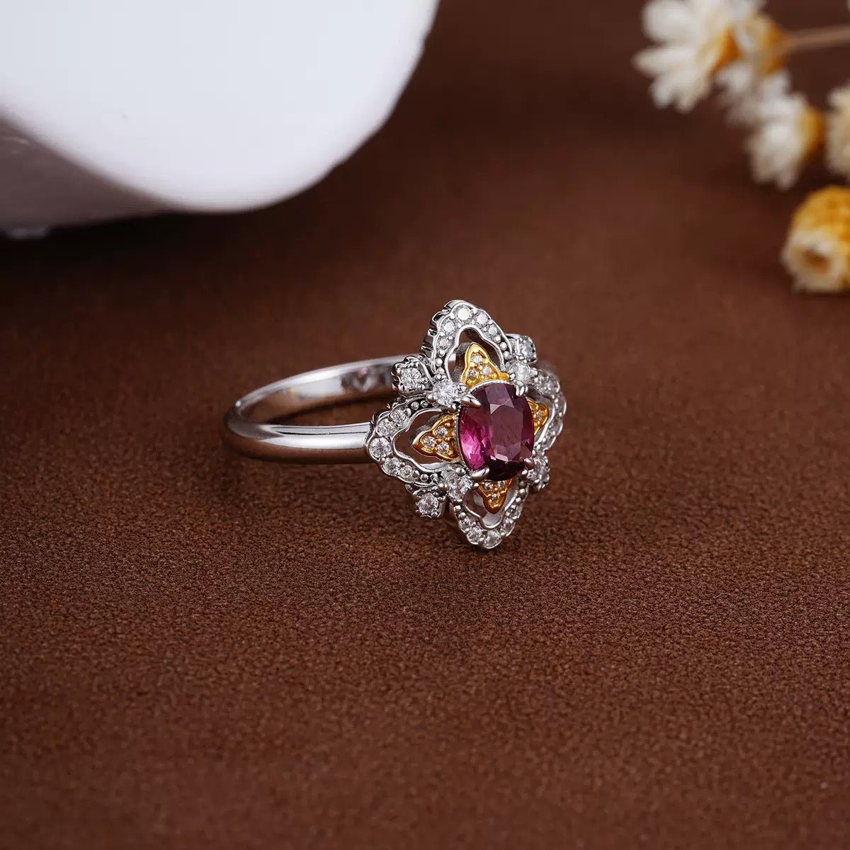 Awakened Time La Rosa di Firenze Renaissance-inspired floral garnet ring captured from an elegant side angle against a textured brown backdrop.