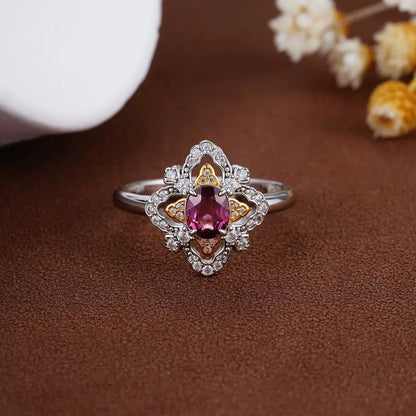 Awakened Time La Rosa di Firenze Renaissance-inspired floral garnet ring displayed on a rich brown background with dried botanical accents.