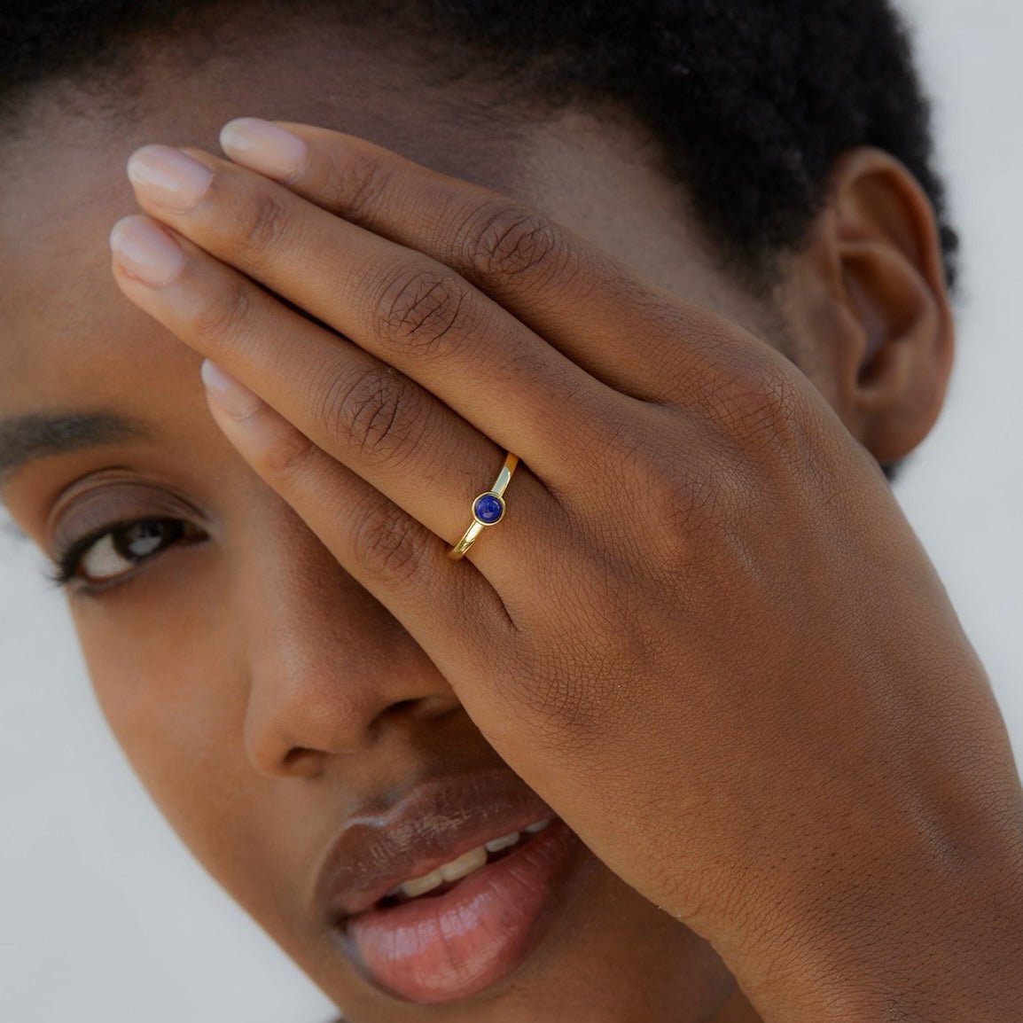 Close-up portrait of a model wearing the Luna Nova Ring with a natural lapis lazuli gemstone set in 18ct gold vermeil