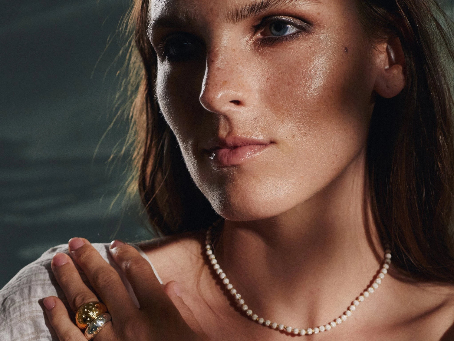Awakened Time model wearing elegant gold jewelry including a statement ring and necklace