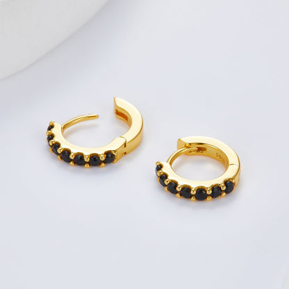 Pair of gold Noir Éclat huggie earrings shown open to display the hinge mechanism and black stones.