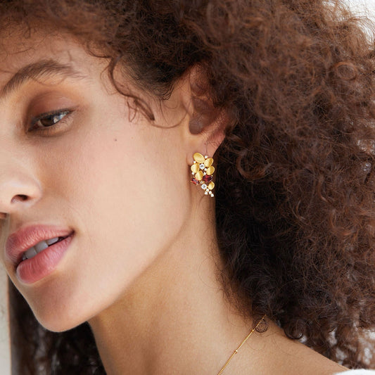 Close-up profile of a model wearing the Opéra de Feu gold cascade earring.