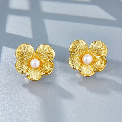 High-angle view of the gold petal pearl studs showing the textured flower petals and freshwater pearl centerpieces.