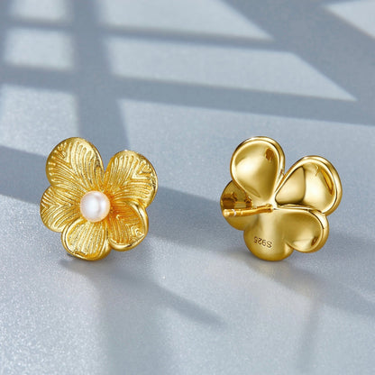 Front and back view of gold petal pearl stud earrings displaying the flower post and backing detail.