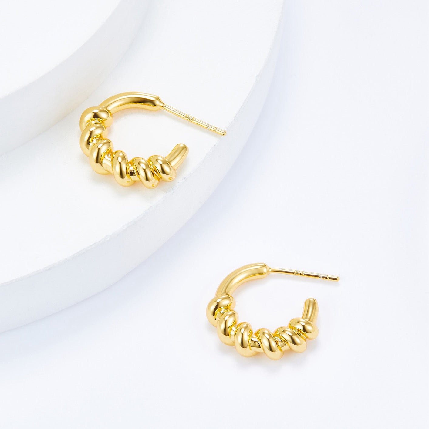 Detailed view of Roma Twist gold vermeil hoop earrings showcasing the sculptural twisted rope texture.