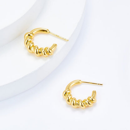 Detailed view of Roma Twist gold vermeil hoop earrings showcasing the sculptural twisted rope texture.