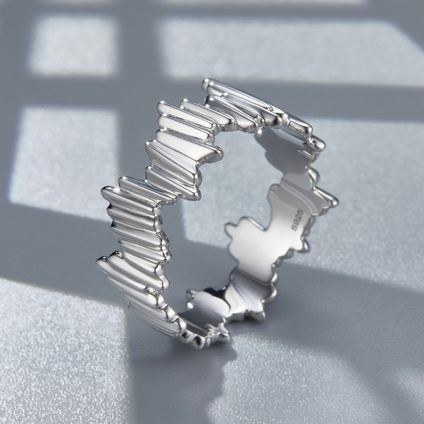 Awakened Time Silver Shard Irregular luxury statement ring in a studio angled display, showcasing its sculptural jagged silhouette, 18ct white gold vermeil finish, and S925 hallmark against a geometric background.