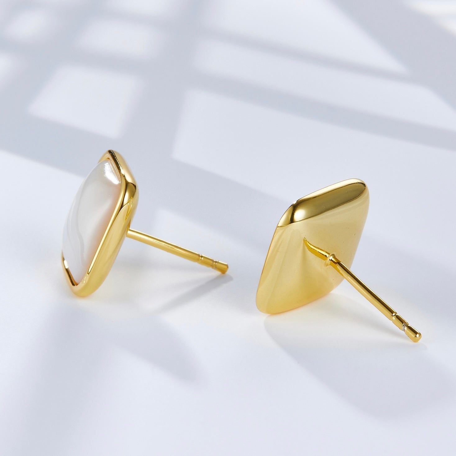 Pair of Soleil Blanc square gold vermeil stud earrings showing the earring posts and polished gold backing.